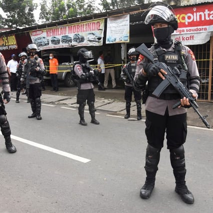 Indonesian armed police officers stand guard outside the house of suspected militants during a raid in Jakarta on Monday. Photo: Antara Foto/Indrianto Eko Suwarso/ via Reuters