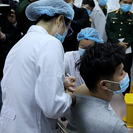 Vietnamese military medical officials give a shot of the Covid-19 vaccine Nanocovax, developed by Vietnamese pharmaceutical firm Nanogen at the Military Medical University in Hanoi. Photo: Vietnam News Agency / AFP