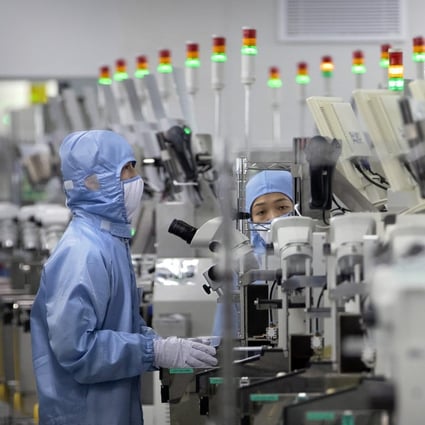 Employees wearing protective equipment work at a semiconductor production facility for Renesas Electronics during a government-organised tour for journalists in Beijing, China on May 14, 2020. Photo: AP Photo