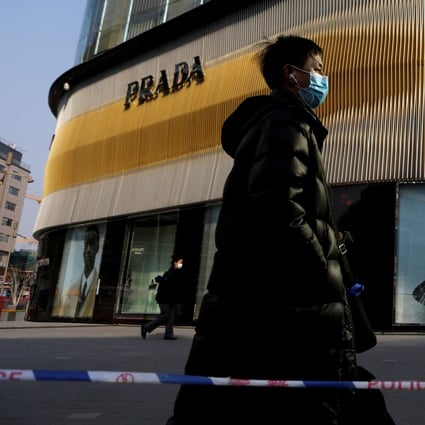 A man walks past a Prada store in Beijing, the city that according to Forbes now has the greatest number of billionaires on the planet. Photo: Reuters