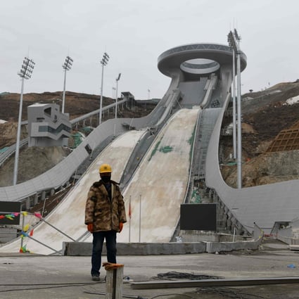 A worker stands at the base of the under-construction ski jumping venue for the 2022 Beijing Winter Olympic Games in Zhangjiakou, 200km northwest of Beijing, on March 17. Photo: AFP