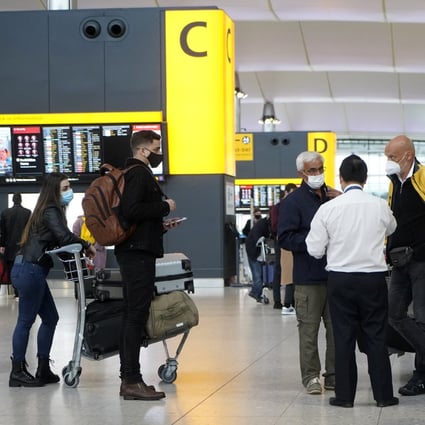 Travellers wearing masks stand around check-in desks at Terminal 2 of Heathrow Airport in London on December 21, 2020, when Hong Kong announced a ban on flights from the UK. Photo: AFP 