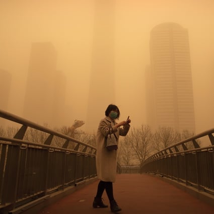A woman walks along a bridge during the morning rush hour in the central business district in Beijing on March 15. Photo: AP