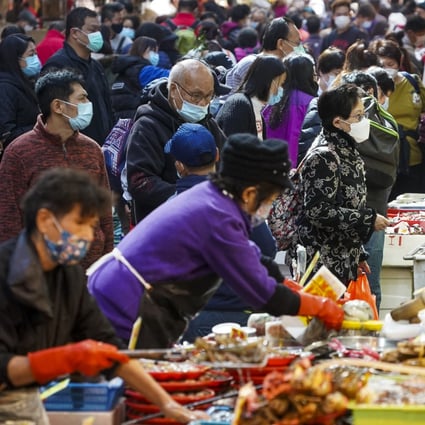 People buy food at a wet market in Wan Chai in December 2020. The e-voucher scheme should not leave behind people and stores that use cash. Photo: Felix Wong