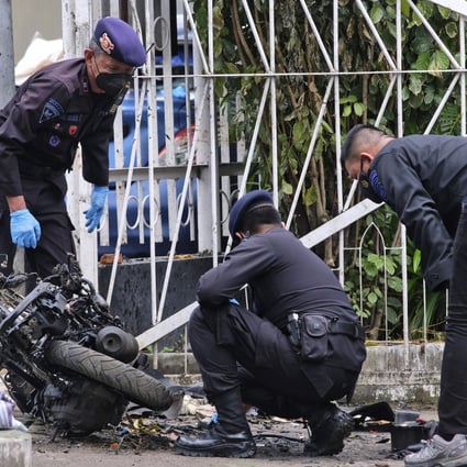 Members of a police bomb squad inspect the wreckage of a motorbike used to carry out a suicide bomb attack in South Sulawesi, Indonesia. Photo: AP