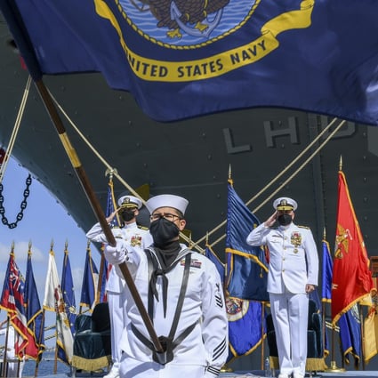 Members of the US Navy salute the ensign for colours during a decommissioning ceremony of the amphibious assault ship USS Bonhomme Richard at Naval Base San Diego on April 14, 2021. Photo: Handout via AP