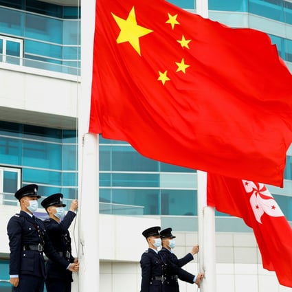 Police officers raise the Chinese and Hong Kong flags at Golden Bauhinia Square in Hong Kong on March 11. Photo: Reuters 