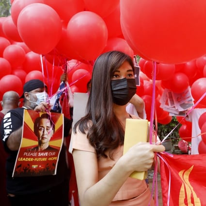 Protesters hold placards and a flag of the National League for Democracy party attached to red balloons during a demonstration against the military coup in Yangon, Myanmar. Photo: EPA