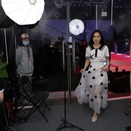 A live streamer promotes a dress during a live-streaming session, inside a booth set up at a show venue during China Fashion Week in Beijing, China, on March 31, 2021. Photo: Reuters