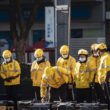 Food delivery couriers for Meituan stand with insulated bags during a morning briefing on a street in Shanghai on Sunday, Nov. 29, 2020.Photo: Bloomberg