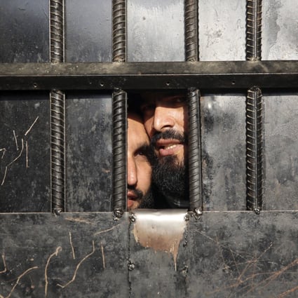 Taliban prisoners watch through the door inside a prison on August 3, 2020, after an attack in the city of Jalalabad, east of Kabul, Afghanistan. Photo: AP 