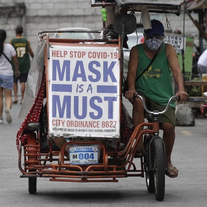 A man in Manila rides his pedicab bearing a slogan to remind people to wear masks. Photo: AP