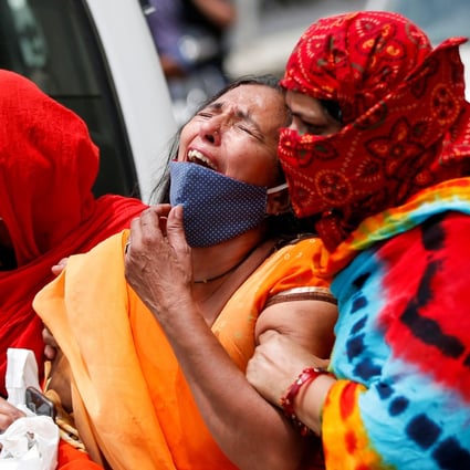 A woman is consoled after her husband died from Covid-19 in Ahmedabad, India. Photo: Reuters