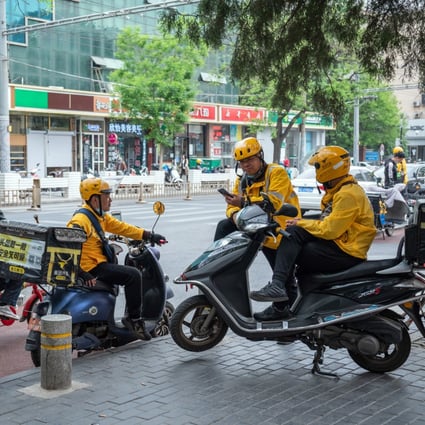 Food delivery couriers for Meituan gather around motorcycles in Beijing on April 21. The Chinese delivery giant is being investigated by Beijing over allegations that it forced merchants to exclusively sell on its platform, the same practice that resulted in Alibaba being fined US$2.8 billion. Photo: Bloomberg