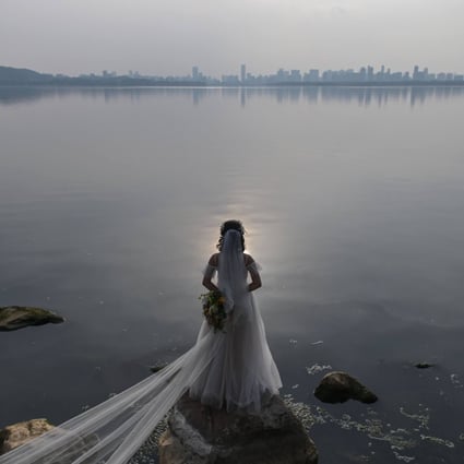 A bride poses for a wedding photographer next to East Lake in Wuhan, in central Hubei province, on April 19, 2020. The new divorce law is another example of the Chinese government’s intervention in family matters. Photo: AFP