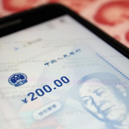 China’s official app for digital yuan is seen on a mobile phone next to 100-yuan banknotes. Photo: Reuters