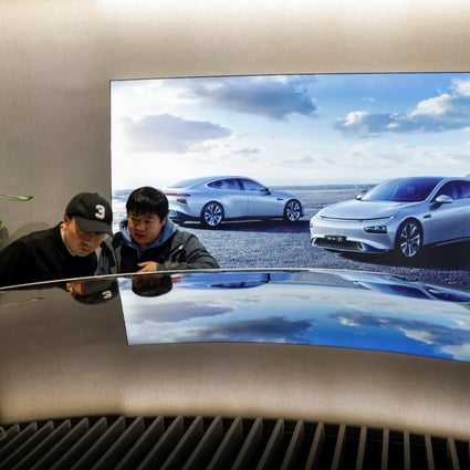 Customers look at an XPeng electric car at a company store in Shanghai, March 11, 2021. Photo: Reuters