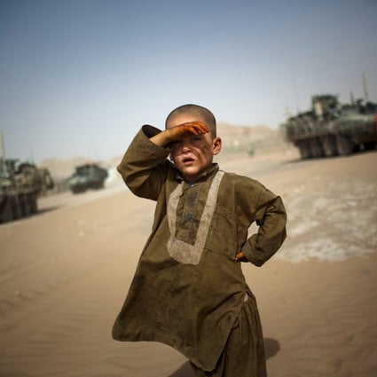 A child looks on as American military vehicles pass his village on the outskirts of Spin Boldak, southeast of Kandahar, Afghanistan. Photo: AP