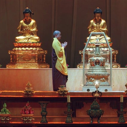 Two monks pay their respects along with thousands of devotees at the Hong Kong Coliseum following the arrival of the sacred Buddha’s tooth relic from Beijing. 