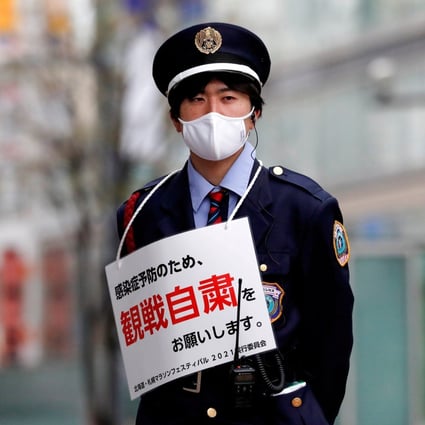 A security guard wears a sign asking members of the public to refrain from lining the route of the Hokkaido-Sapporo Marathon, a test event for the Tokyo 2020 Olympics. Photo: Reuters