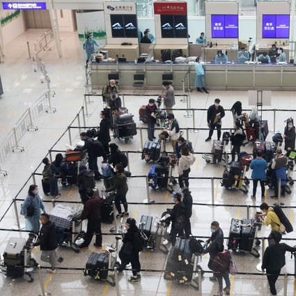 Arriving passengers get in line to be transported to designated quarantine hotels, at Hong Kong International Airport on December 22, 2020. Photo: Nora Tam