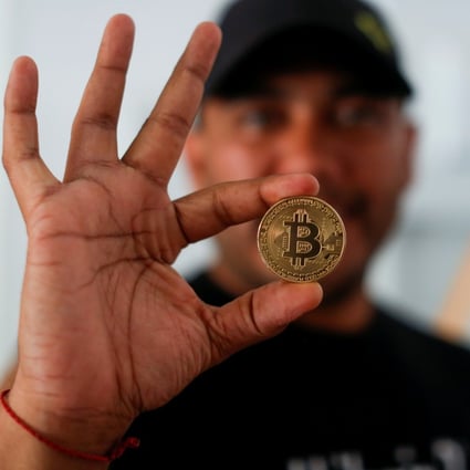Bitcoin enthusiast Carlos Bonilla shows a physical representation of bitcoin at a Bitcoin Beach support office at El Zonte Beach in Chiltiupan, El Salvador, on June 10. Photo: Reuters