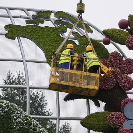 Workers in Beijing set up flower decorations with a map showing the US, on June 13. Leaders of the world’s largest economies have unveiled an infrastructure plan for the developing world to compete with China’s global initiatives. Photo: AP
