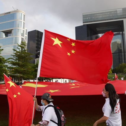 Hong Kong residents hold a national flag aloft in support of a major overhaul of the city’s political system praised on Wednesday by Beijing’s top envoy to the city. Photo: Winson Wong