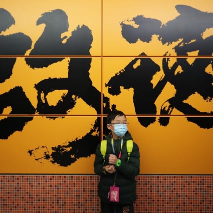 A young passenger at the new Kai Tak MTR station stands against a wall that is splashed with Abe Au’s calligraphic work depicting the area’s name. Photo: Winson Wong