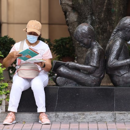 A woman reads her vaccination pamphlet outside the Hong Kong Central Library in Causeway Bay after having her Sinovac Covid-19 vaccine on June 19. Photo: Nora Tam