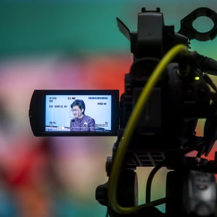 Chief Executive Carrie Lam Cheng Yuet-ngor is seen through a camera viewfinder as she addresses a news conference on June 21 in Hong Kong. The city is set to shorten hotel quarantine to seven days for fully vaccinated residents and non-residents travelling from most places, subject to conditions, but the 21-day quarantine remains for the rest. Photo: Bloomberg