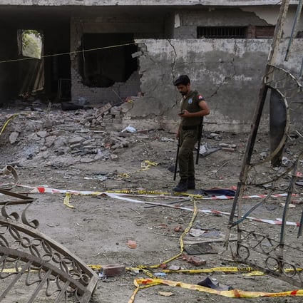 A policeman inspects the site of the June 23 car bomb that killed three people in Lahore. Photo: AFP