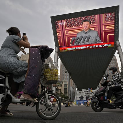 A woman on an electric scooter films a large screen outside a shopping mall showing President Xi Jinping’s speech on the 100th anniversary of China’s Communist Party on July 1. Although the speech was intended for the domestic audience, it was bound to have an international effect. Photo: AP 