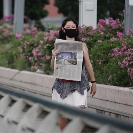 A woman reads a newspaper in Singapore. Photo: Xinhua