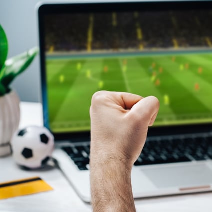 A fan cheers for his favourite team as he watches a game on his laptop, while making bets at bookmaker’s website. Photo: Shutterstock 