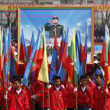 People hold a portrait of Wa State’s leader Bao Youxiang during a ceremony to mark the 30th anniversary of Wa State on April 17, 2019. Photo: EPA-EFE