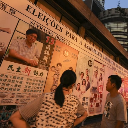 Macau residents look at posters for the 2017 Legislative Assembly Election on September 17 that year. Incumbent lawmakers are among some 20 pro-democracy candidates disqualified from the 2021 race. Photo: Dickson Lee