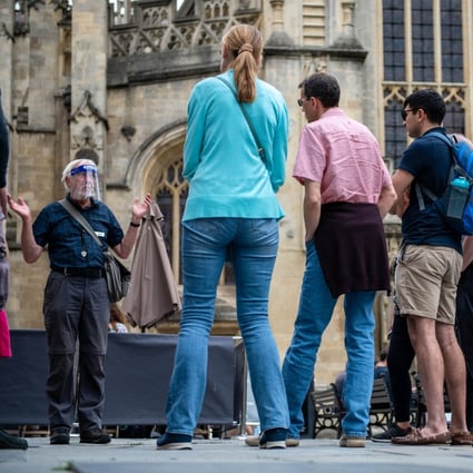 A tour guide wearing a face shield speaks to a group outside Bath Abbey in the UK, on July 5. The Delta variant is spreading, even in countries with high vaccination rates like Britain. Photo: Bloomberg 
