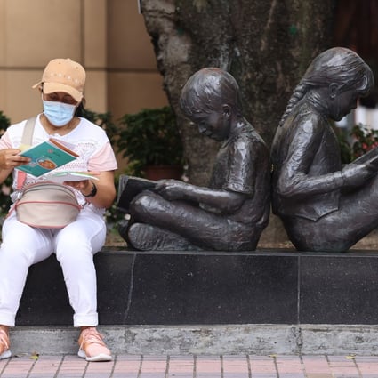 A woman reads a vaccination pamphlet outside the Hong Kong Central Library in Causeway Bay on June 19. Photo: Nora Tam