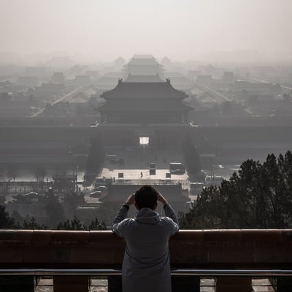 A man takes photos of the Forbidden City as thick haze engulfs Beijing on December 9, 2019. China has committed to being carbon neutral by 2060. Photo: EPA-EFE