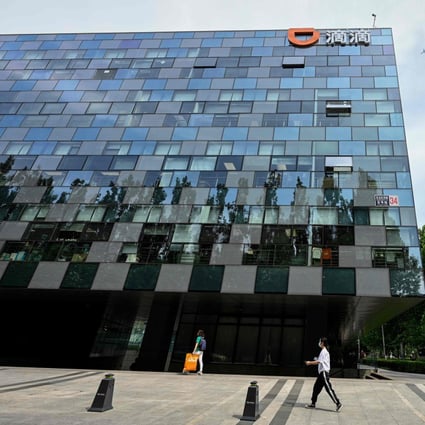 People walk past the headquarters of Didi Chuxing in Beijing on July 2. The “Didi effect” – the fallout from Beijing’s launch of a data security probe against the ride-hailing group just days after its initial public offering in New York – has wreaked havoc with China-sensitive assets. Photo: AFP