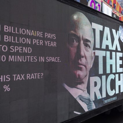 A small group of protesters held a rally in Times Square in New York on July 27, calling for a higher tax rate on the wealthiest Americans, following news of billionaires’ Jeff Bezos and Richard Branson’s privately-funded trips into space. Photo: EPA-EFE