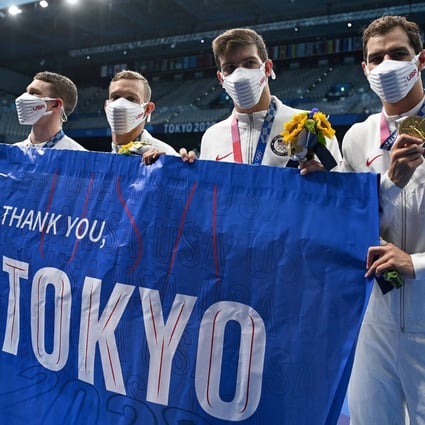 Gold medallist swimmers Ryan Murphy, Caeleb Dressel, Zach Apple, and Michael Andrew, from the US, carry a flag reading “Thank you Tokyo” after winning the final of the men’s 4x100m medley relay at the Tokyo 2020 Olympic Games on August 1. Photo: AFP