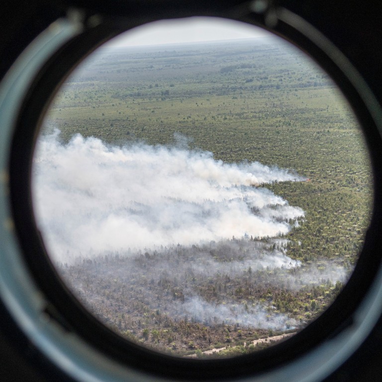 Smoke rises from fires at a palm oil plantation, as seen from the window of a water bombing helicopter of the Local Disaster Management Agency (BPBD) during an operation near Palembang, South Sumatra province, Indonesia, on July 26. Photo: Reuters 