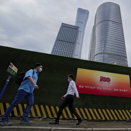People walk past a poster to mark the 100th anniversary of the founding of the Chinese Communist Party on display at the central business district in Beijing on July 6. China is reshaping its business landscape with a strong Marxist ideological push and an ultranationalist sentiment. Photo: AP