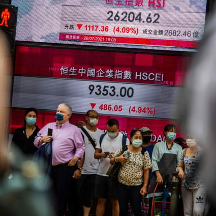 People stand in front of an electronic display showing the Hang Seng Index in Central on July 26 after stocks plunged as tuition firms were hammered by China’s decision to reform the private education sector by preventing them from making profits. Photo: AFP
