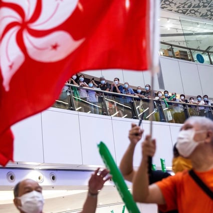 A man waves the Hong Kong flag in a shopping mall in the city while celebrating Siobhan Haughey’s silver medal in the women’s 100m freestyle swimming final, at the Tokyo Olympics on July 30. Photo: AFP