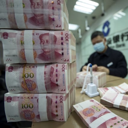 A teller counts 100 yuan bills at a bank in Nantong, eastern Jiangsu province, on February 1. Photo: Imaginechina