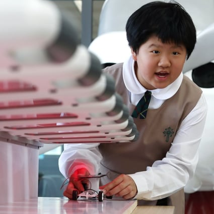 A girl experiments with a solar car during a STEM promotional activity organised by the Education Bureau at the SKH Holy Cross Primary School in Kowloon City, Hong Kong, on March 20, 2018. Photo: Nora Tam