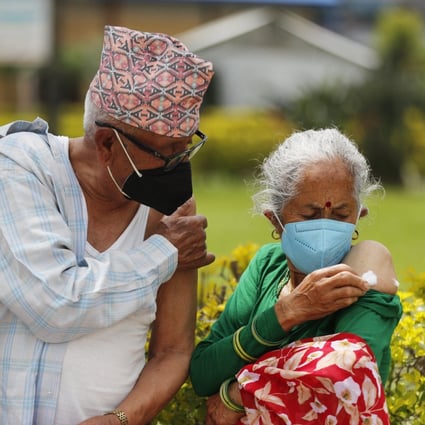 An elderly Nepalese couple wait outside after receiving a Covid-19 vaccine in Kathmandu, Nepal, on August 9. Photo: AP